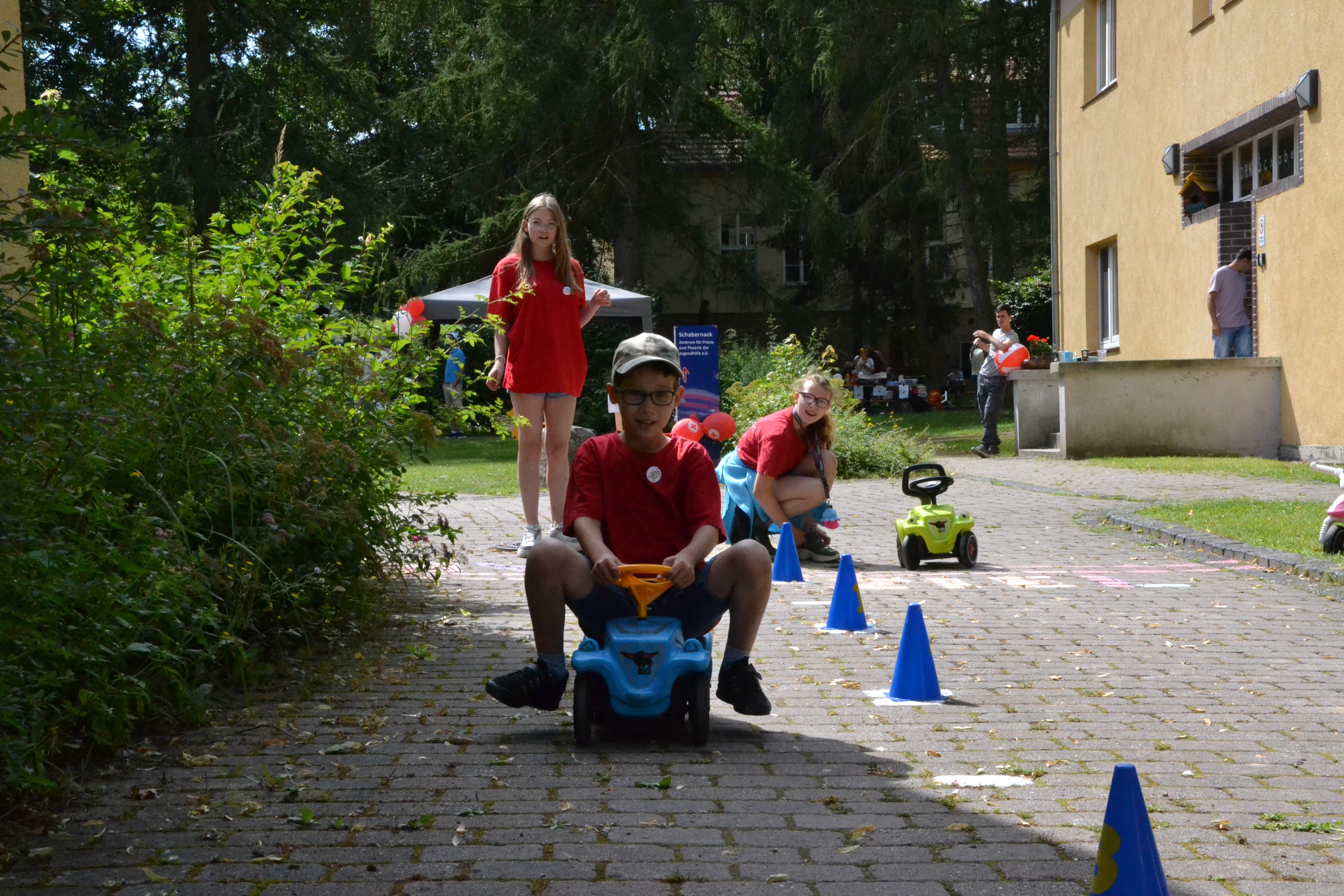 Bild zeigt John auf dem Bobby-Car beim durchfahren des Parcours 