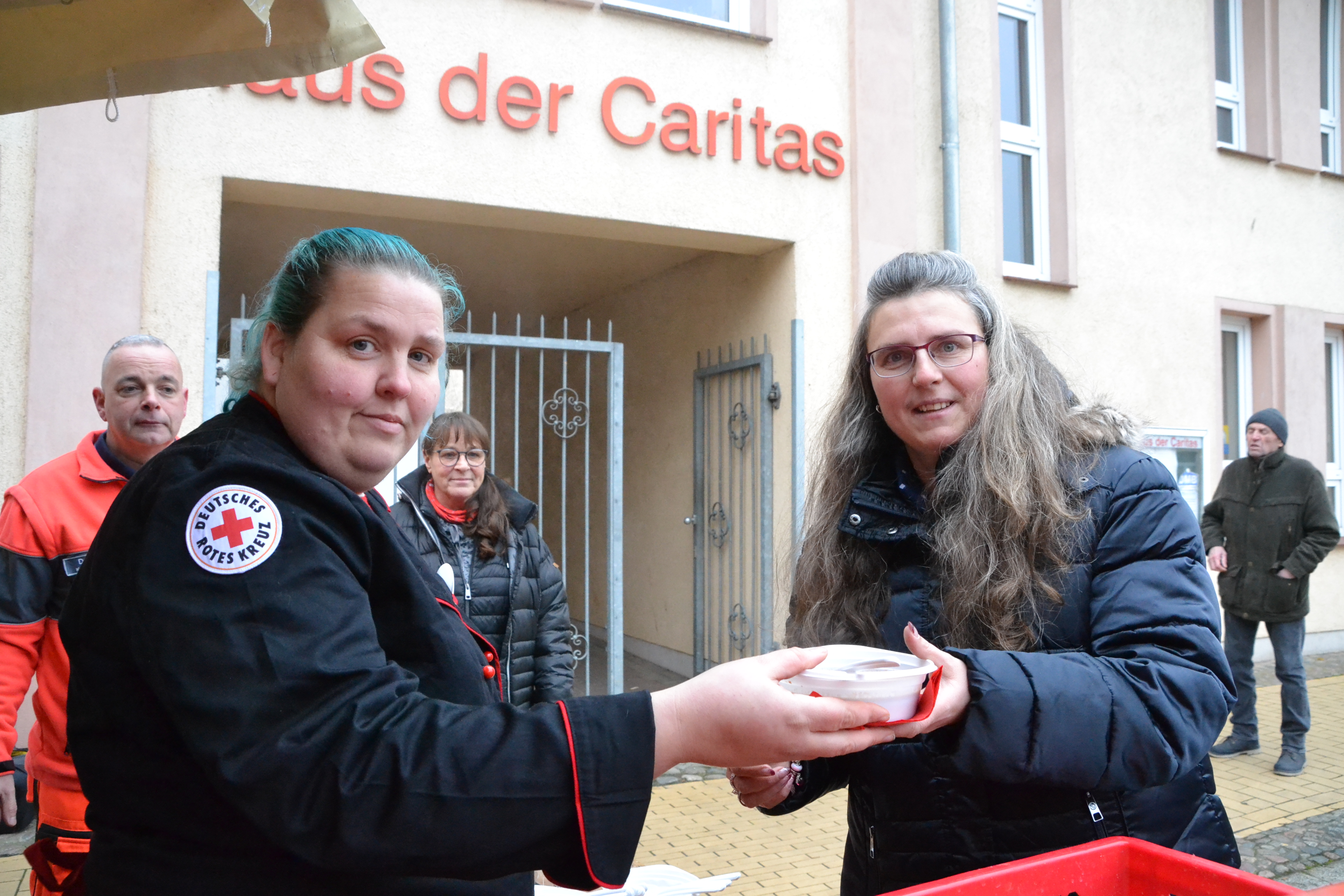 Bild zeigt Feldköchin Janine Sprengel bei der Übergabe des Essens an Frau Holm