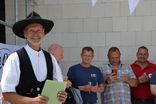 Bild zeigt Herrn Tobias Asse vorne links welcher den Richtspruch für das neue Gebäude vorträgt